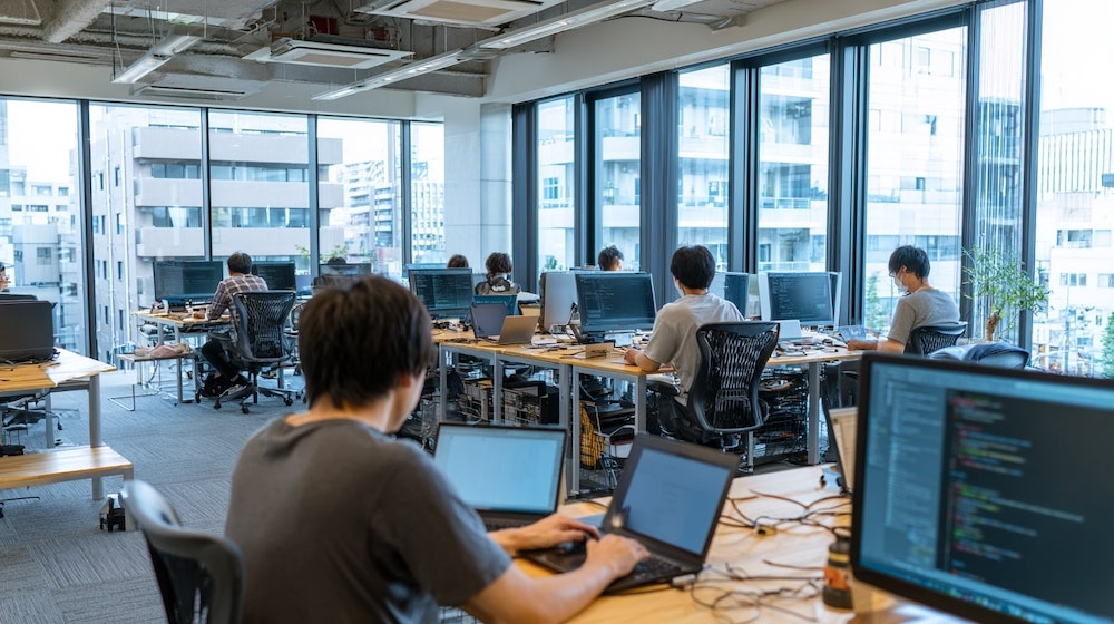 K社のオフィス風景。エンジニアたちが開発に取り組む様子
